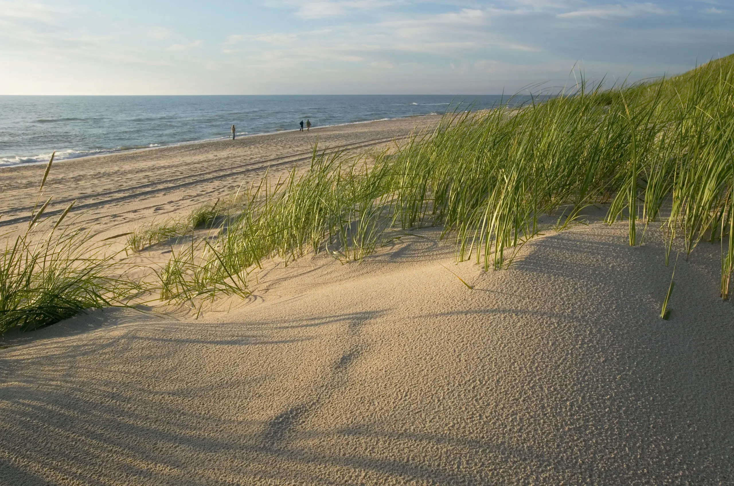 Baltic coast beach with three people walking on the sand